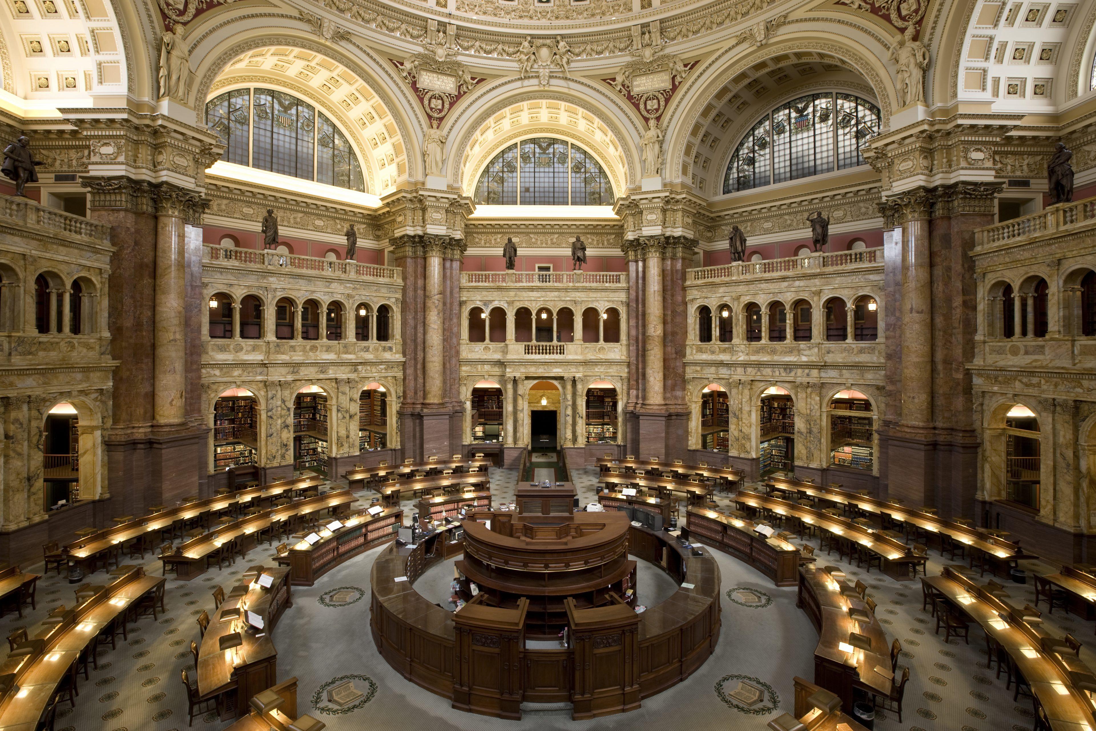 A great library reading room, desks in a circle under a domed ceiling