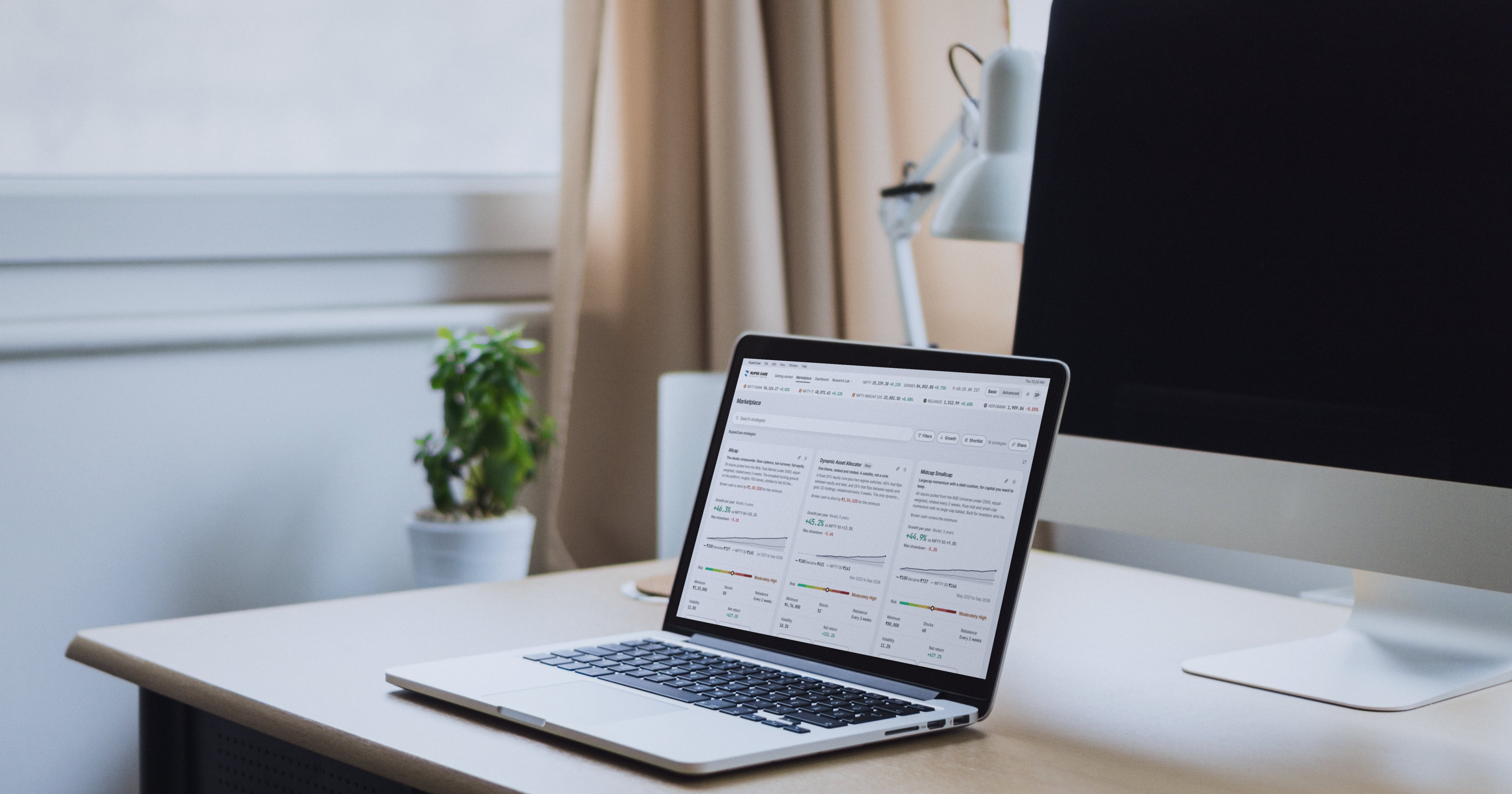 A laptop on a bright desk by a window showing the RupeeCase strategy marketplace