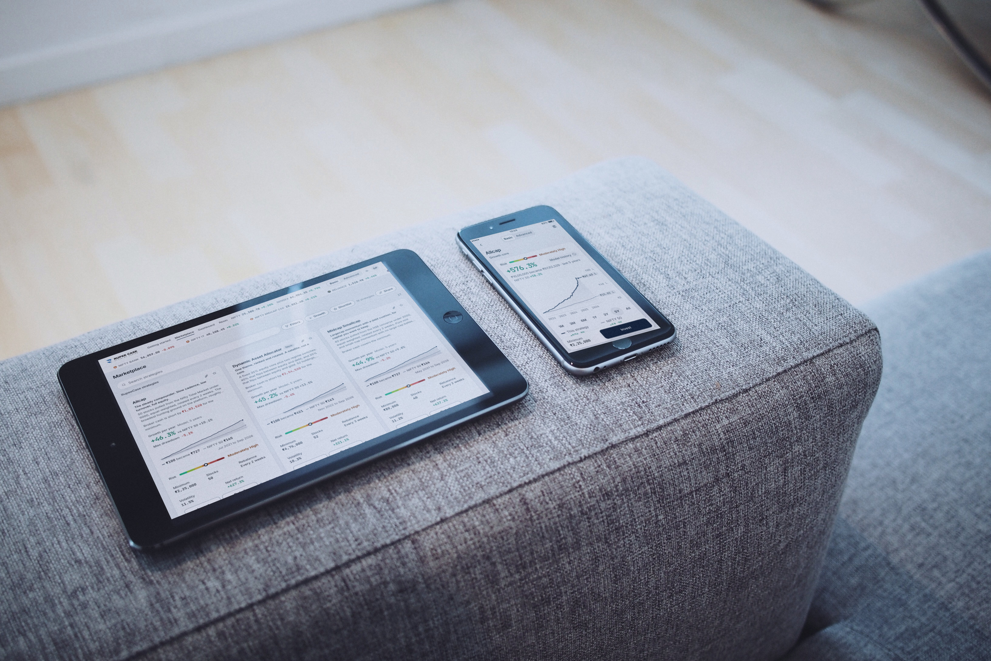 A tablet and a phone in daylight showing the RupeeCase marketplace and a strategy, light theme