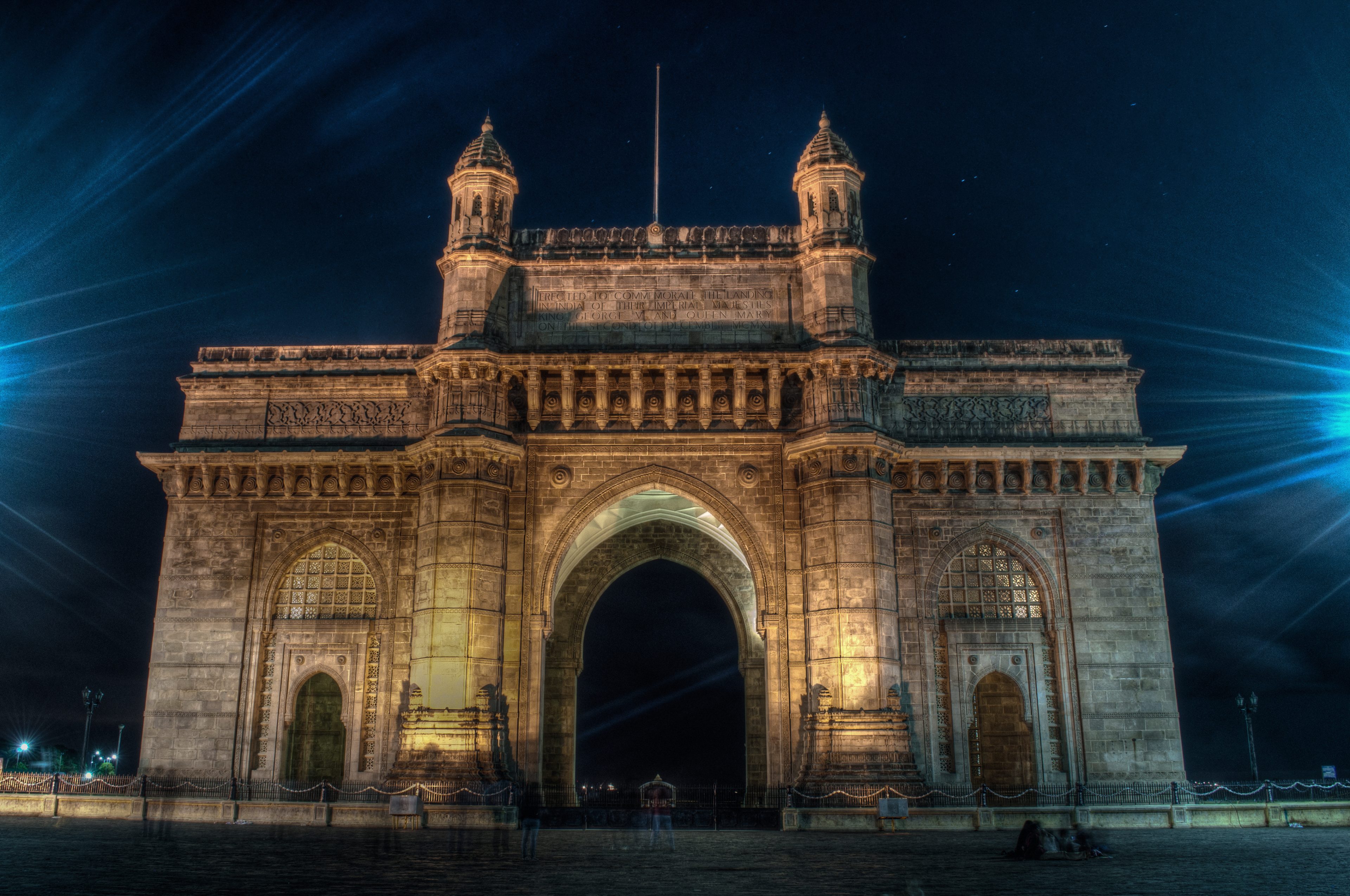 The Gateway of India in Mumbai lit at night under a deep blue sky
