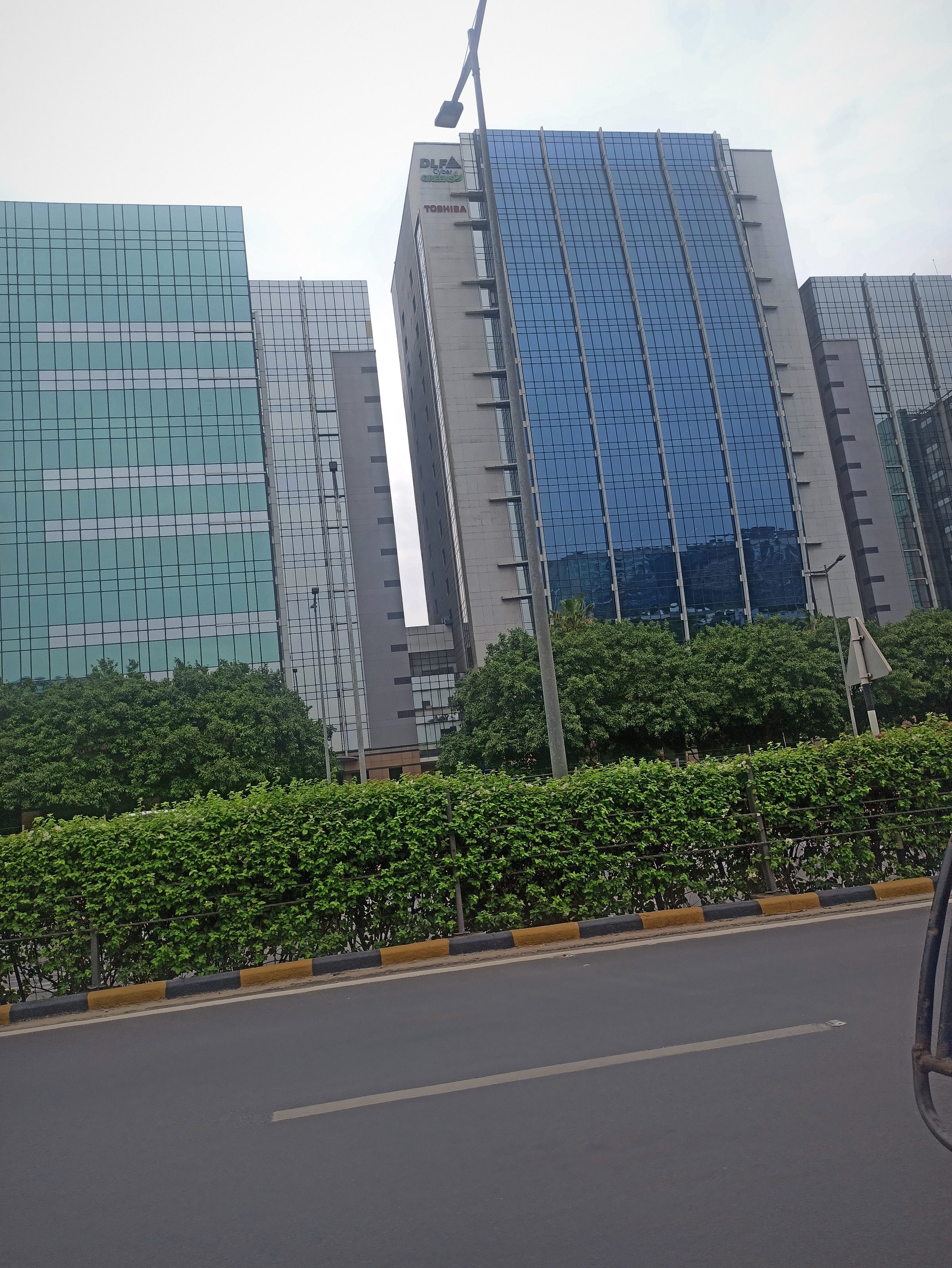 Glass office towers in a Noida business park under a pale sky