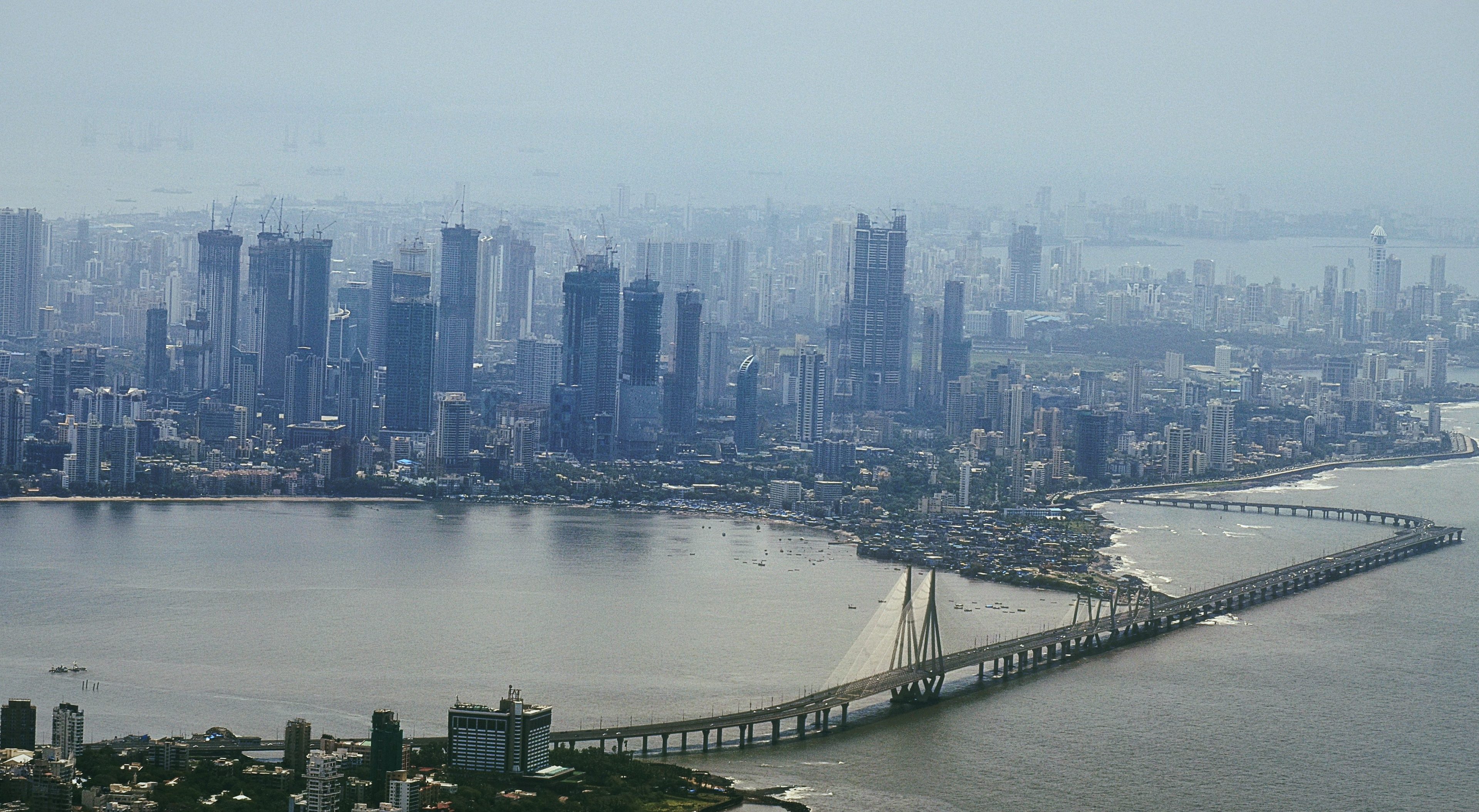 Mumbai from the air: the towers of Worli and Lower Parel above the bay, the Bandra Worli Sea Link curving across the water